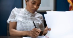 Frau schreibt in eine Akte 