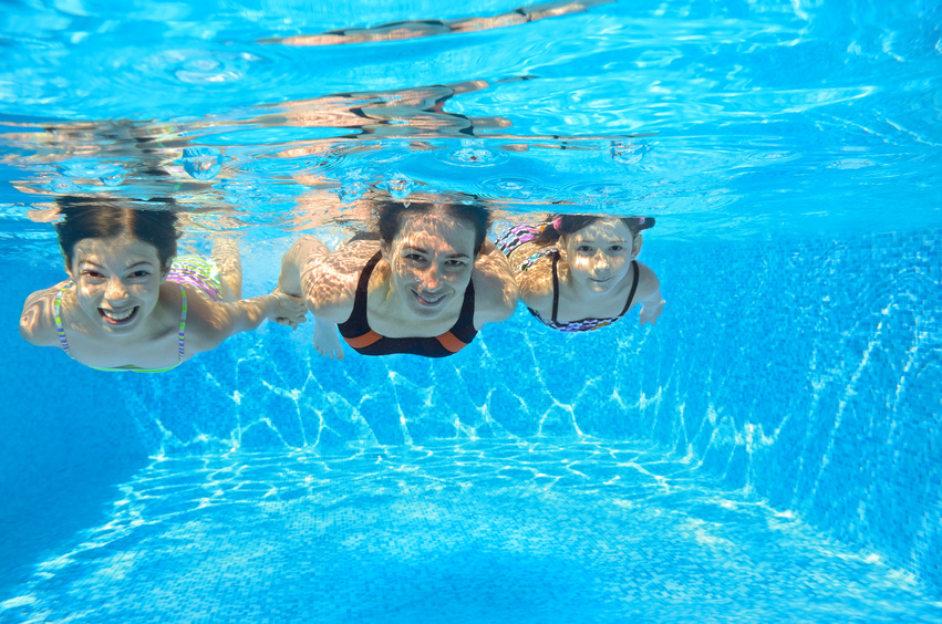 Happy family swim underwater in pool, having fun on vacation