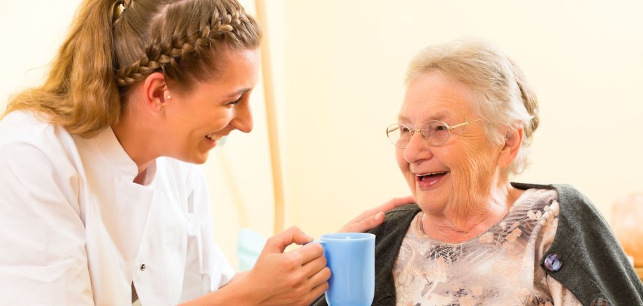 Alter und Pflege - Pflegerin und Seniorin im Altenheim